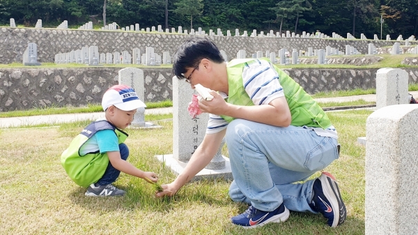 ▲현대엔지니어링 임직원 및 임직원 가족이 국립서울현충원에서 묘역 정화 봉사활동을 하고 있다.