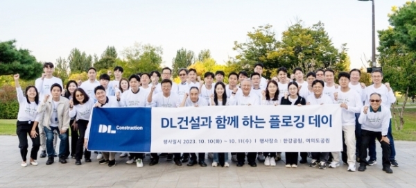▲지난 10일 서울 여의도한강공원에서 DL건설 직원들이 플로깅 행사 후 기념 촬영하고 있다.