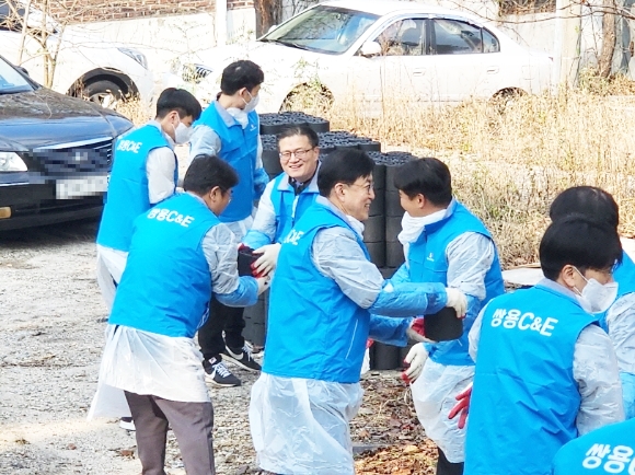 ▲쌍용C&E 본사 임직원들이 서울 성북구 일대에서 열린 ‘사랑의 연탄 나눔’ 행사에서 연탄을 전달하고 있다.