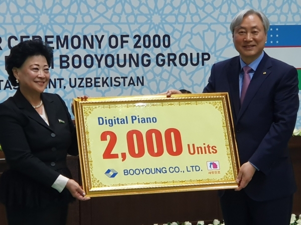 ▲부영그룹 신현석 고문(오른쪽)이 우즈베키스탄 아그리피나 신 유아교육부 장관에게 디지털피아노 2000대 기증판을 전달하고 있다.