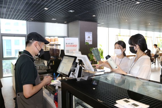 ▲DL이앤씨 직원들이 8일 서울시 종로구 돈의문 디타워에 위치한 D라운지카페에서 개인 컵(텀블러)을 사용해 음료를 주문하고 있다.