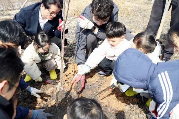 ▲나무심기에 참여한 아이들이 사과나무를 심고 있다.